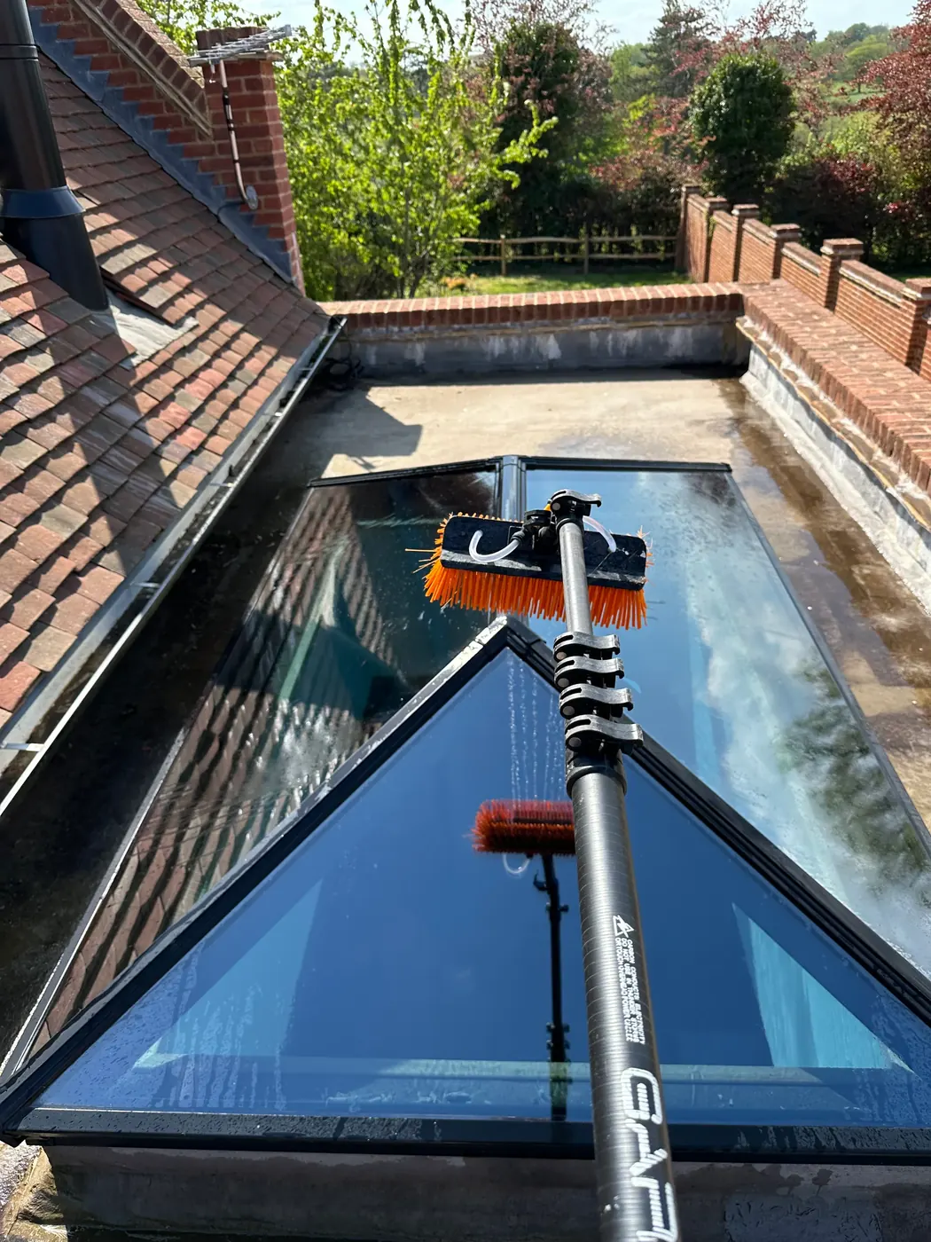 Water-fed pole cleaning a glass conservatory roof