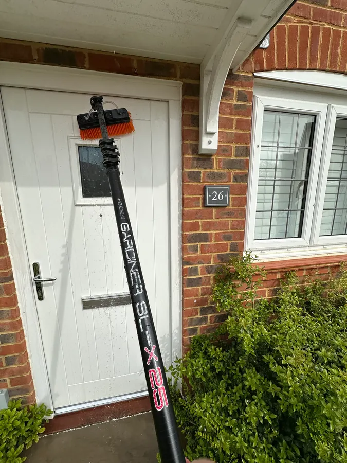 Water-fed pole brush cleaning a garage door